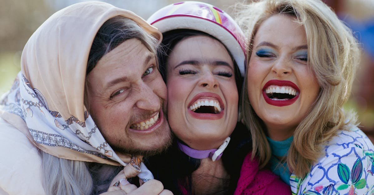 Three friends laughing joyfully outdoors, capturing happy moments together.
