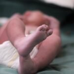 Close-up of a newborn's feet on a hospital bed, capturing the essence of new life.