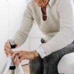 Elderly woman adjusting rollator in a bright, cozy room.