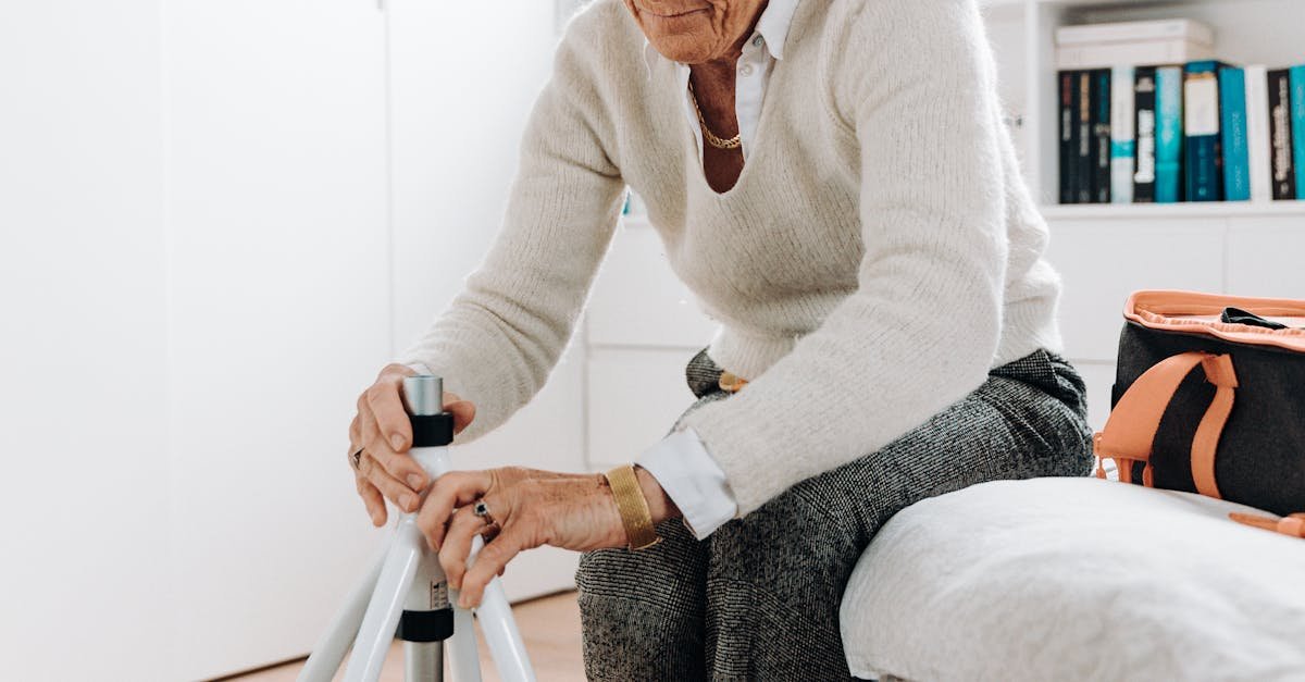 Elderly woman adjusting rollator in a bright, cozy room.