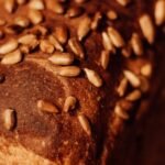 Close-up of freshly baked homemade whole grain bread topped with various seeds, showcasing artisanal texture.
