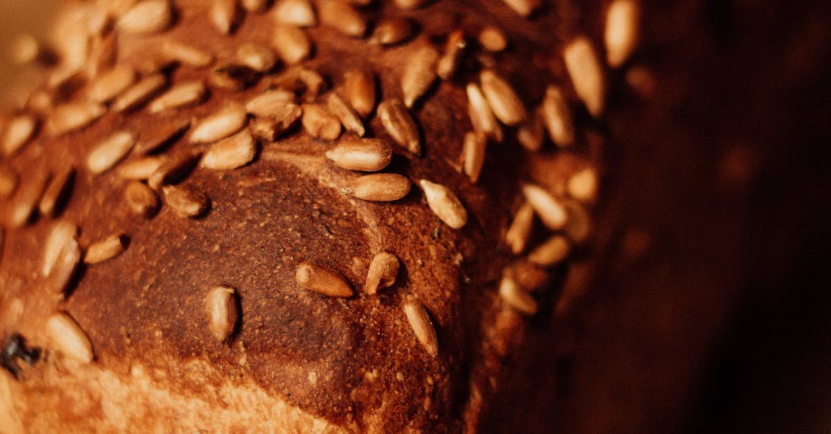 Close-up of freshly baked homemade whole grain bread topped with various seeds, showcasing artisanal texture.