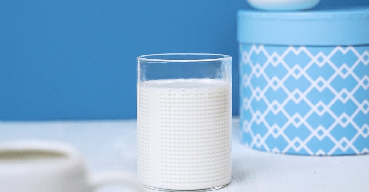 A clean and simple still life featuring a glass of milk with blue decor, offering a serene aesthetic.