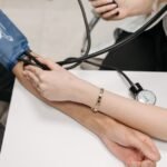 A doctor measures a patient's blood pressure with a sphygmomanometer during a consultation.