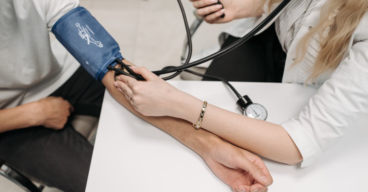A doctor measures a patient's blood pressure with a sphygmomanometer during a consultation.