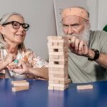 Senior man and woman playing Jenga, creating a fun and engaging atmosphere indoors.
