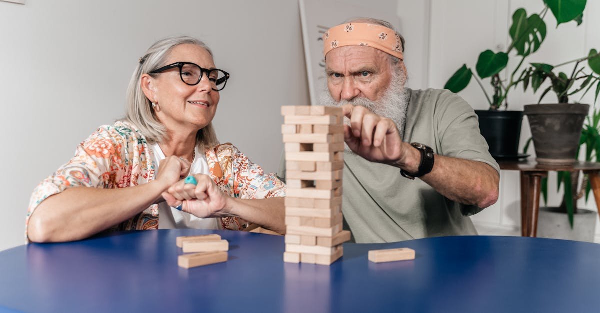 Senior man and woman playing Jenga, creating a fun and engaging atmosphere indoors.
