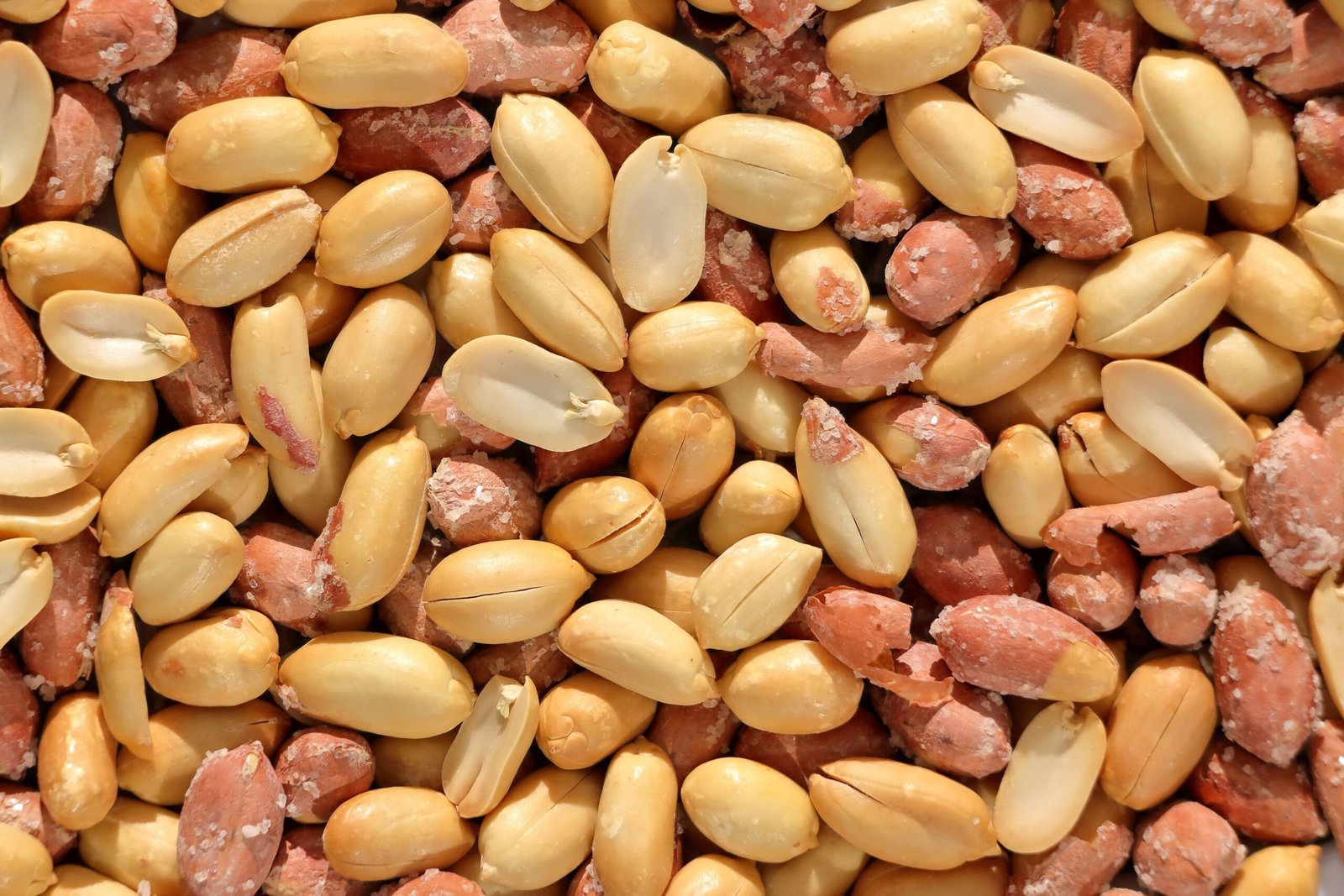 A detailed close-up image of roasted peanuts in their shells, showcasing texture.